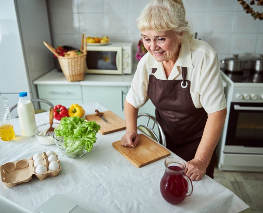Seniorin nutzt Alltagshilfen zum kochen
