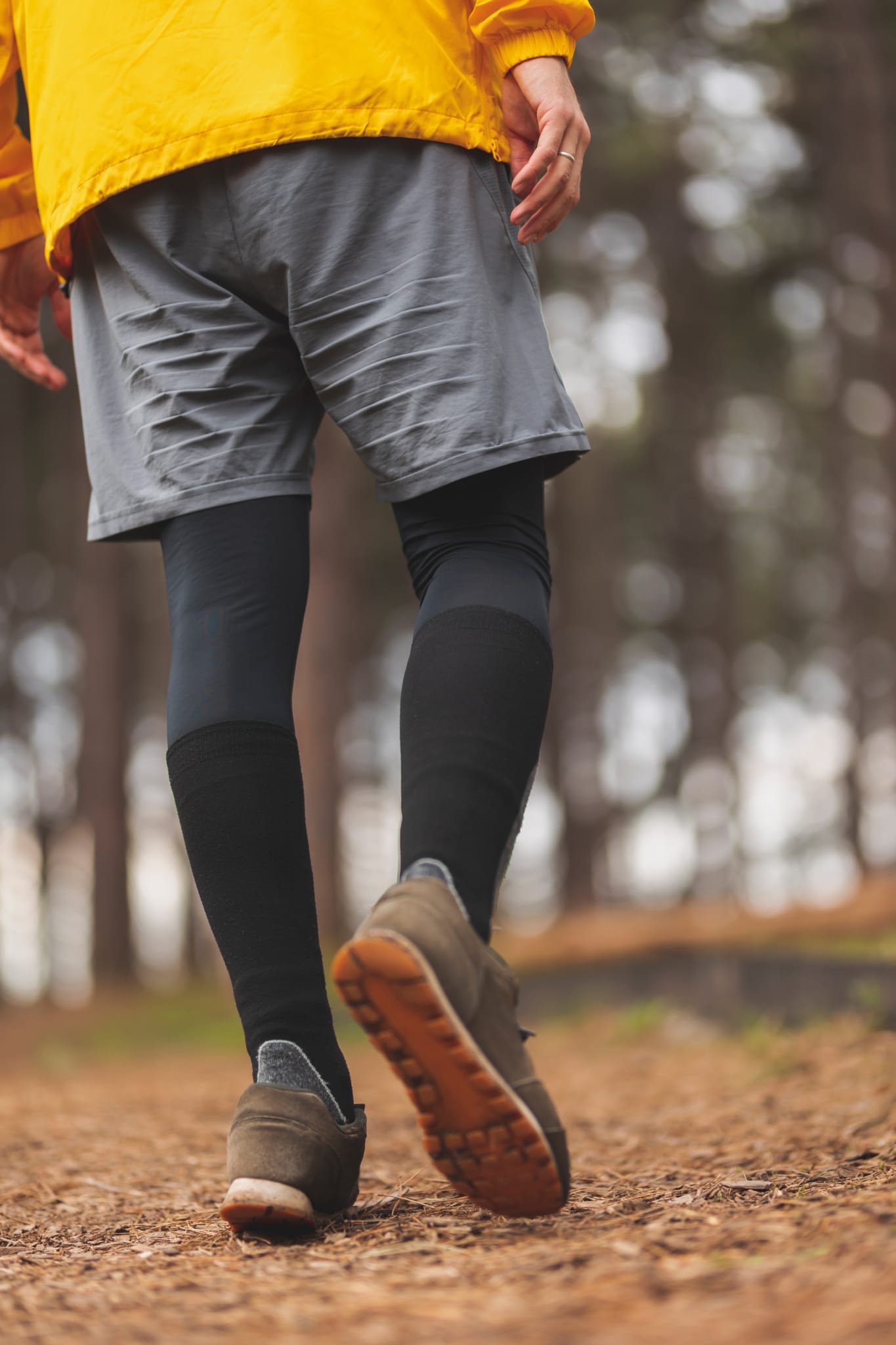 Mann von hinten der einen Waldweg entlang läuft